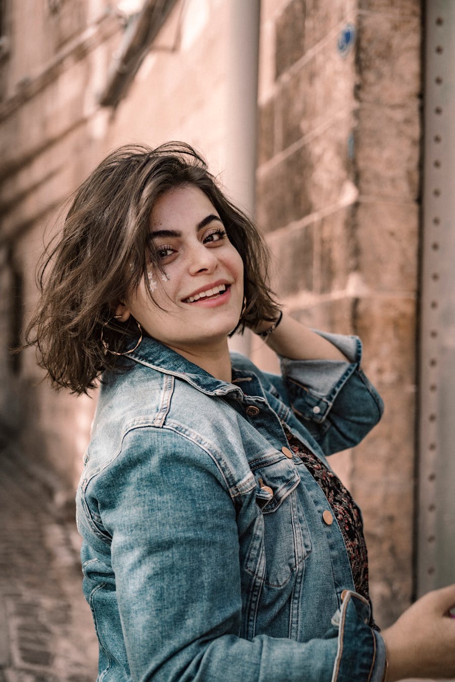A young woman smiling in a denim jacket